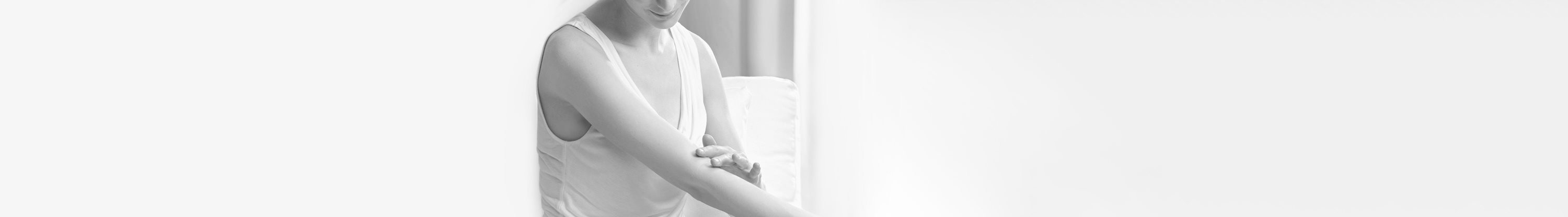 Woman touching the crook of her arm.